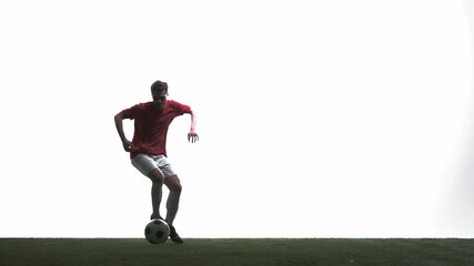 Focused soccer player controlling ball in studio silhouette. Concept of shot accuracy, athletic power, football performance, training routine, competitive sport and advertising visuals.