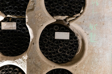 Vintage wine bottles stacked in a stone cellar, creating a rustic and timeless atmosphere. Ideal for themes of wine, storage, and tradition.