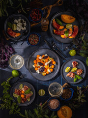 Fresh melon, prosciutto, and feta cheese appetizers on dark table