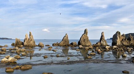 夕映えの干潟に映る橋杭岩の岩峰群