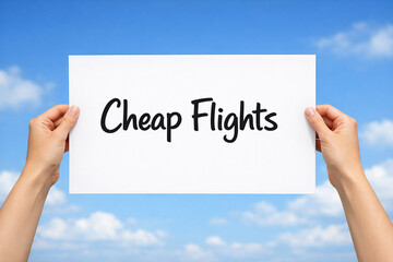Hands holding a white paper sign that reads cheap flights against bright blue sky