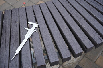 Caliper metal tool on wooden bench background