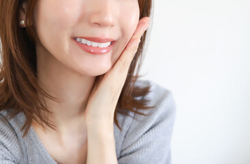 頬に手を当てて笑う女性