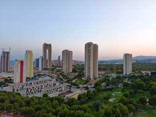 Fototapeta premium city skyline overview, aerial perspective of modern city with green spaces and ongoing construction