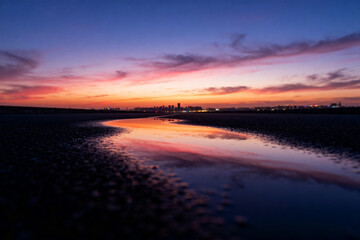 Sunset Over River with City Skyline Reflection