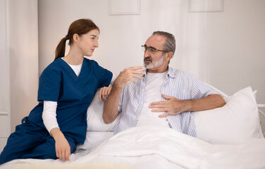 Fototapeta premium A woman or medical caregiver is speaking with an elderly man to seek advice or assistance regarding elderly care.