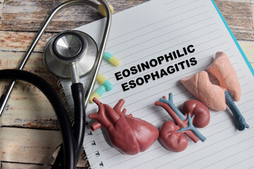 Concept of eosinophilic esophagitis write on book isolated on Wooden Table.