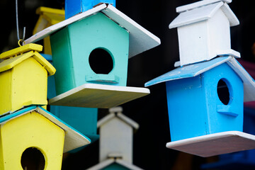Colorful Wooden Birdhouses Hanging in a Market Setting