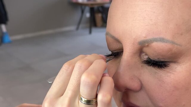 Applying makeup to an adult woman Studio, makeup artist and women with tools, photoshoot, glow cosmetics. Production, model and makeover with brush on set, behind the scenes and people with equipment