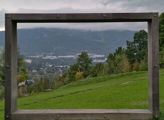 Fototapeta premium peaceful valley with distant settlements, serene alpine scenery with layered mountain silhouettes