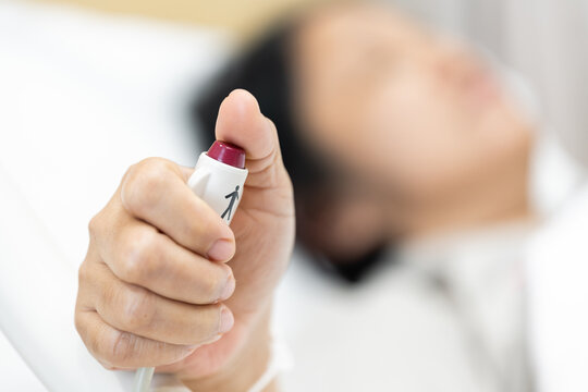 Close up woman patient hand pushing nurse call button inside bed in room hospital.Patient press red emergency button to calling nurse for help assistance remote control.Rescue safe life.
