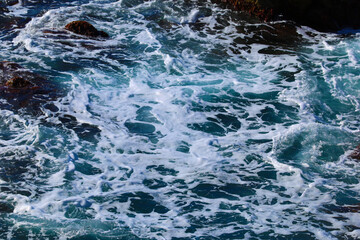 Beach by the sea with foam and spray from the waves