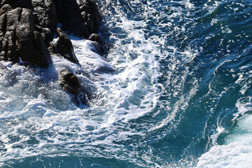 Beach by the sea with foam and spray from the waves