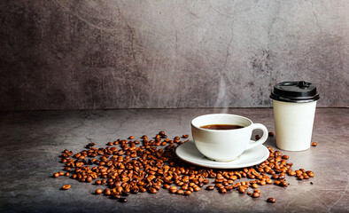 Coffee cup with roasted beans and takeaway cup on concrete background