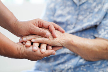 Caregiver holding hands Asian elderly woman patient, help and care in hospital.