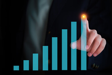 Close-up of a hand interacting with a holographic display showing upward trending bar graphs.