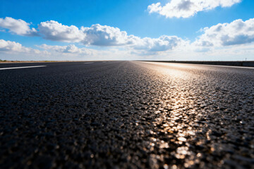 Asphalt Road Under Blue Sky with Fluffy Clouds