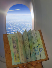 CLOSE UP: Woman traveler holds up her passport next to the airplane window