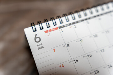 Close-up of a spiral-bound calendar displaying June 2026, showcasing dates and a clear layout to...