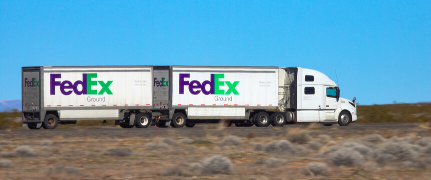 CLOSE UP: White FedEx 18 wheeler drives across the Utah desert on a sunny day.