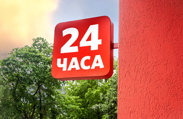 Working 24 hours, sign on facade of building. Inscription on russian: 24 hours