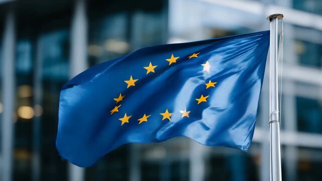 32Close-up of the EU flag rippling in the wind, reflected in the mirrored fa&ccedil;ade of a contemporary government building, emphasizing democracy and strong continental partnership