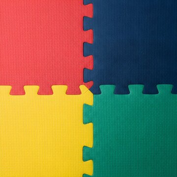 Vibrant Red, Blue, Yellow, and Green Interlocking Foam Puzzle Mats Background Texture