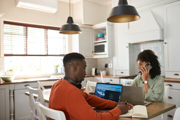 Obraz premium Young multiracial couple working remotely at a kitchen table