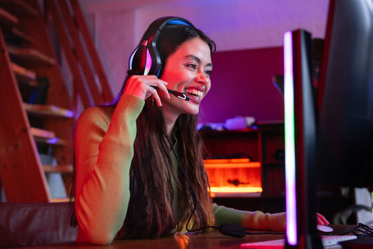 Smiling female gamer enjoying gaming experience at home