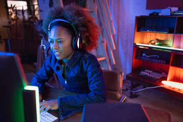 Smiling female Gamer Engaged with a Computer Screen