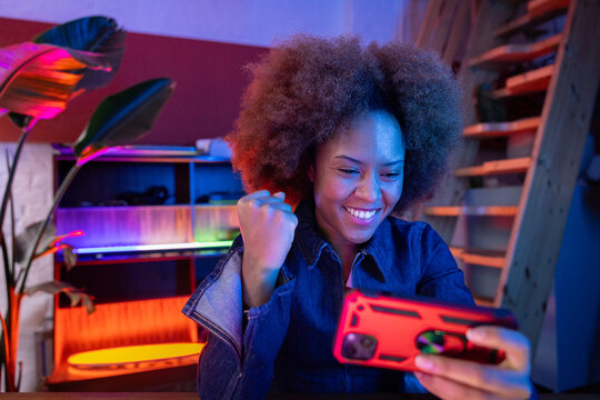 Excited female gamer celebrating mobile game success