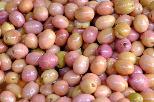 Close-up view of pink olives sold at a delicatessen. Breakfast olives. Traditional Turkish olive farming. Healthy eating. Deli products. Organic farming. Olives from Edremit, Gemlik, and Antakya.
