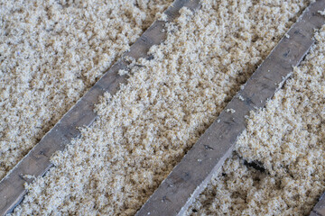 Texture naturelle de laine d'isolation brute pour la rénovation d'une maison et l'amélioration énergétique d'un sol, doux et fibreuse, évoquant authenticité, artisanat et matières textiles naturelles. © Thomas