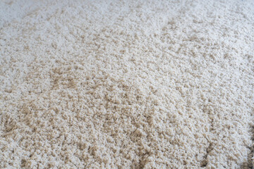 Texture naturelle de laine d'isolation brute pour la rénovation d'une maison et l'amélioration énergétique d'un sol, doux et fibreuse, évoquant authenticité, artisanat et matières textiles naturelles. © Thomas