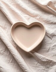 Heart Shaped Ceramic Dish on Wrinkled Pink Fabric Surface Top Down View