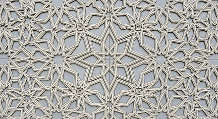 Close-up of intricate geometric patterns, repeating star and diamond shapes. Details of the design are in relief, with silver-toned lines