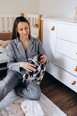 Woman mother checking and folding cloths at kids room