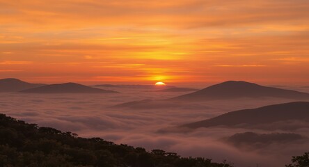 Majestic sunrise over a mountain range, with peaks emerging from a sea of clouds