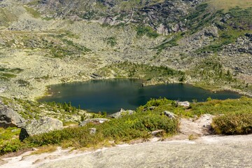 Mountain landscape. A beautiful blue lake among mountain peaks and cliffs. Lake Karovoe. Ergaki Nature Park