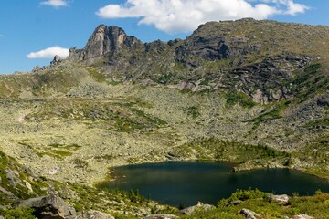 Mountain landscape. A beautiful blue lake among mountain peaks and cliffs. Lake Karovoe. Ergaki Nature Park