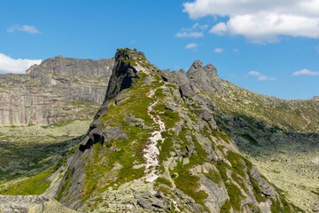 A hiking trail running along a mountain slope.  View from above. Ergaki Nature Park.