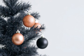black christmas tree with copper-colored ornaments, close-up, on a white background.