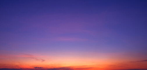 Beautiful purple and orange sunset sky background. Vibrant twilight sky with soft clouds at dusk....