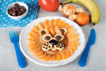 Breakfast food art of kids - Lion pancake with tangerines, banana and chocolate on white plate