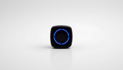 An electronic device with a blue light, placed against a white surface. The device has a square shape and appears to be designed for a portable purpose