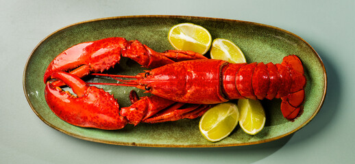 Plakat Lobster on a plate, Whole Lobster seafood, gourmet food, steamed lobster with big claws on a plate with lemon, top view, flat lay, from above. Art design, close-up. 