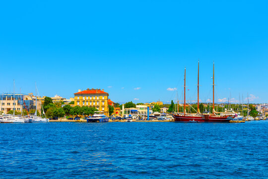 Scenic Zadar city harbor specifically Fosa harbor area in Croatia. Picturesque marina with various boats, including large traditional sailing vessels, set against a backdrop of historic buildings 