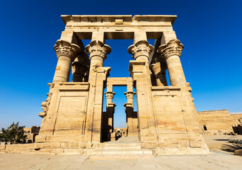 Kiosk Trajana w zespole świątynnym File w Asuanie – starożytna architektura egipska na tle błękitnego nieba © adr77