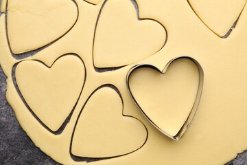 Obraz premium Raw dough and heart shaped cookie cutter on table, top view