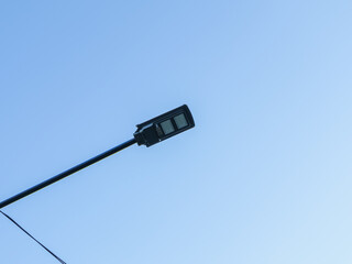 LED street light with natural light illuminating the clear blue sky, creating a modern and energy-efficient urban lighting solution